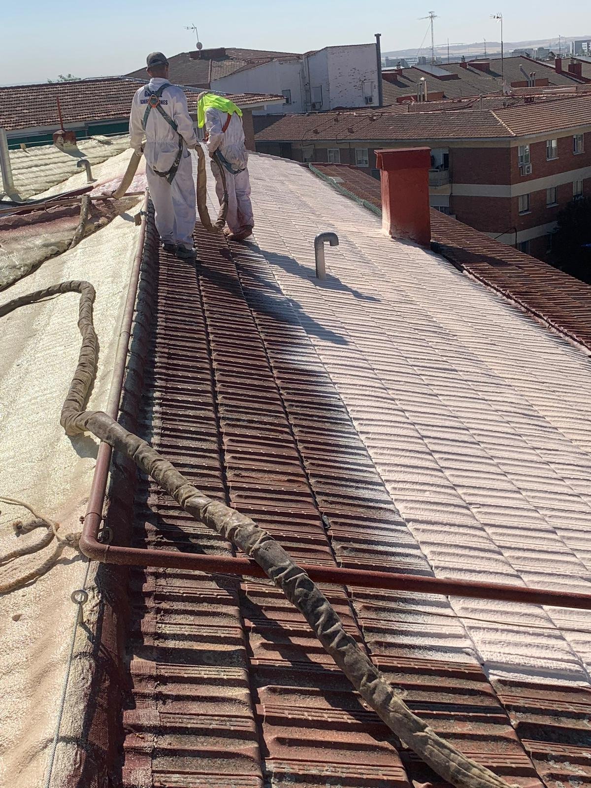 Obreros aplicando espuma aislante en un tejado