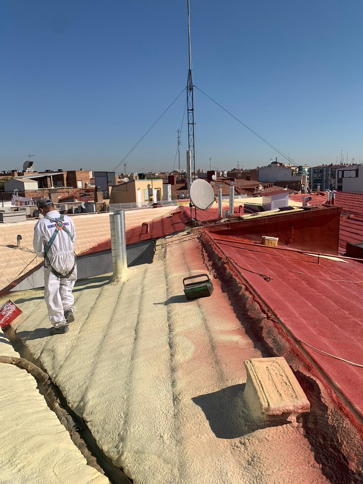 Trabajadores aplicando aislante en un tejado desde la azotea